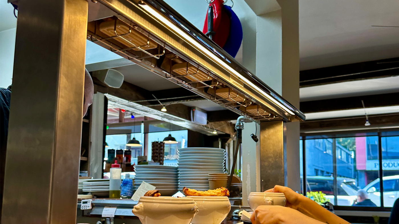 Buffet setup with plates and food in a restaurant kitchen.
