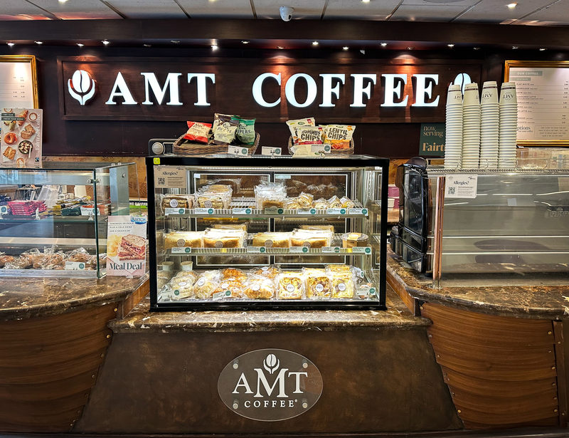 AMT Coffee shop interior with display cases and counter.
