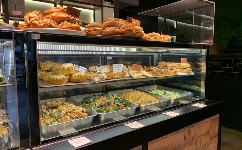 Display case with various food items including pastries and salads in a restaurant setting.